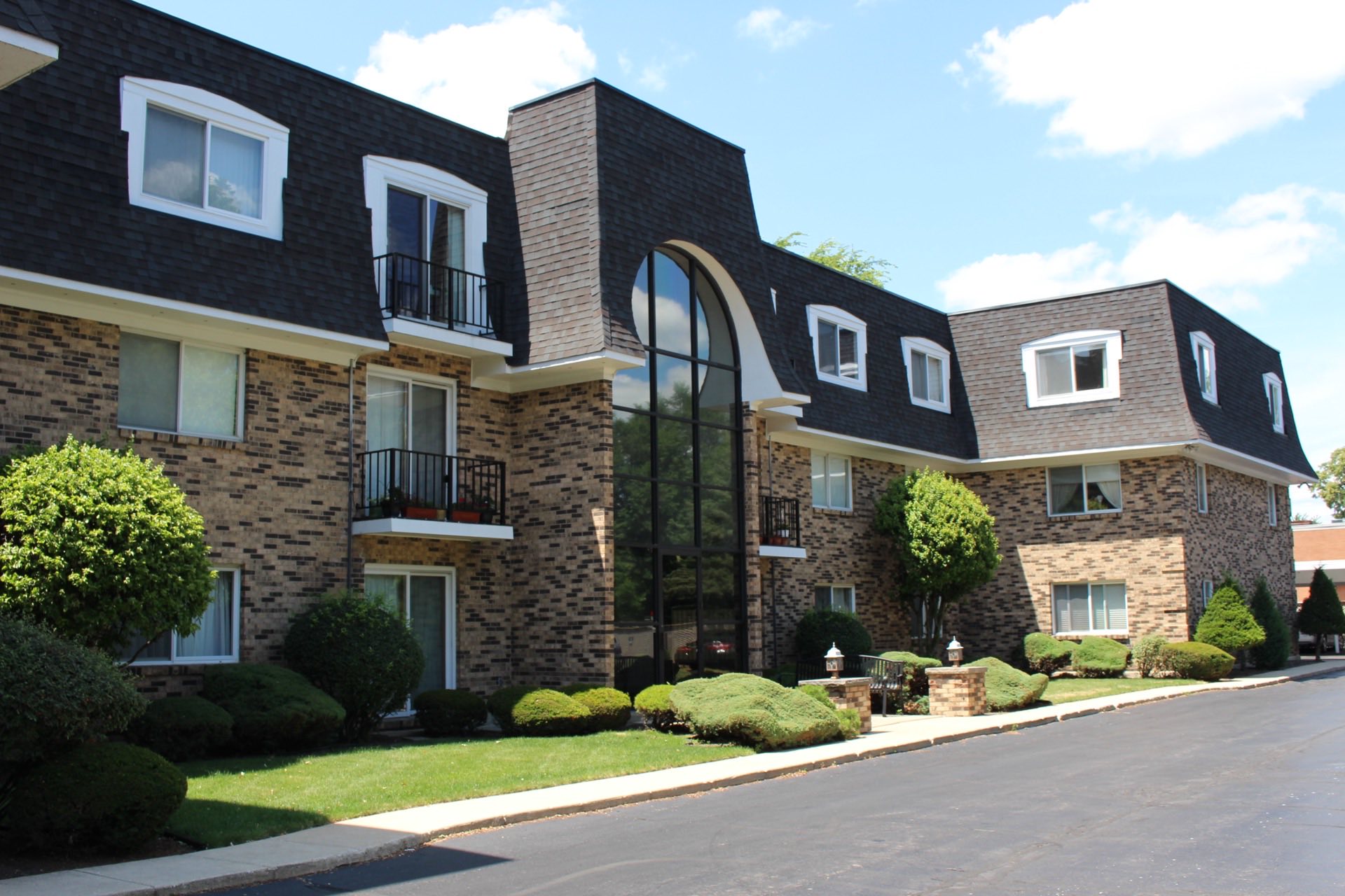 Brick building with soaring lobby windows and shingle roof.